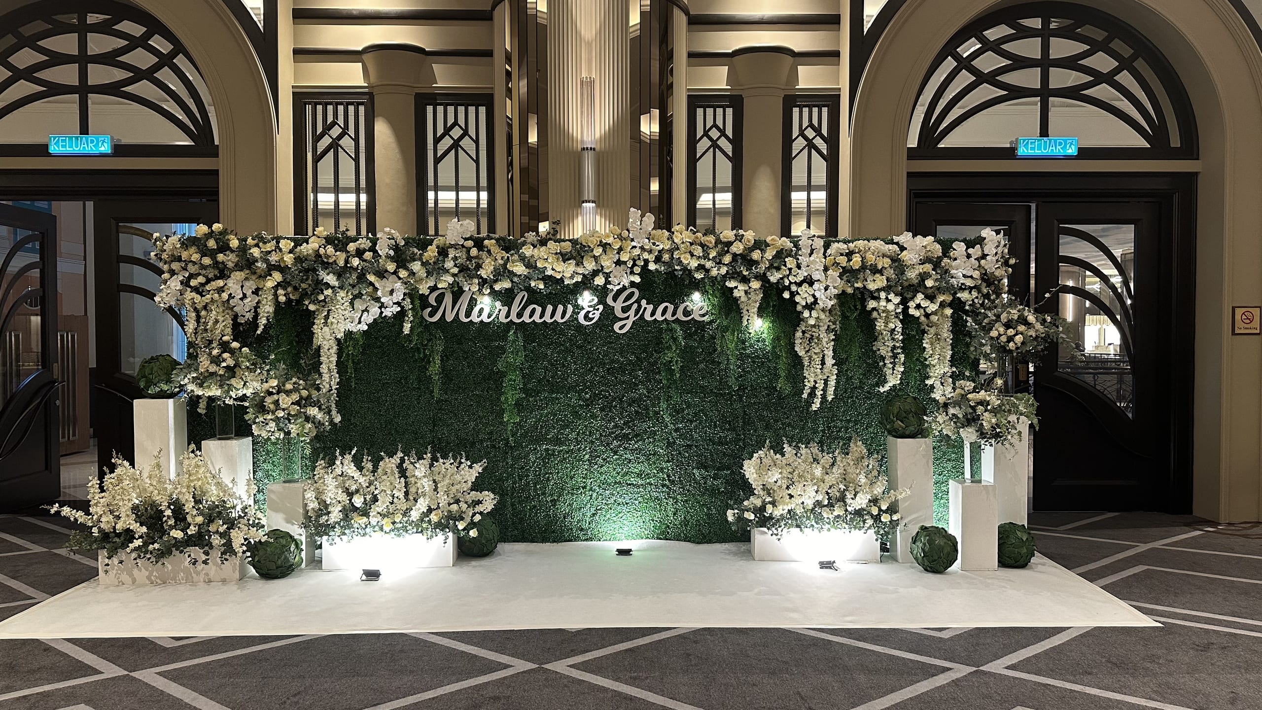 Elegant wedding reception backdrop of white florals and greenery